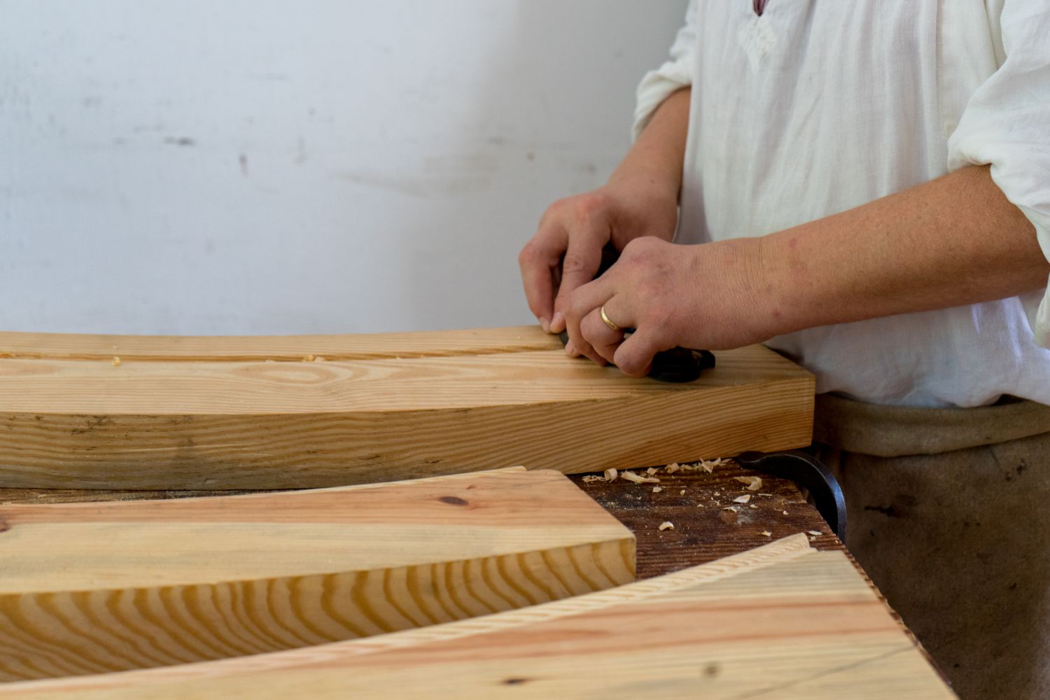Planches de bois brut posées sur l'établi