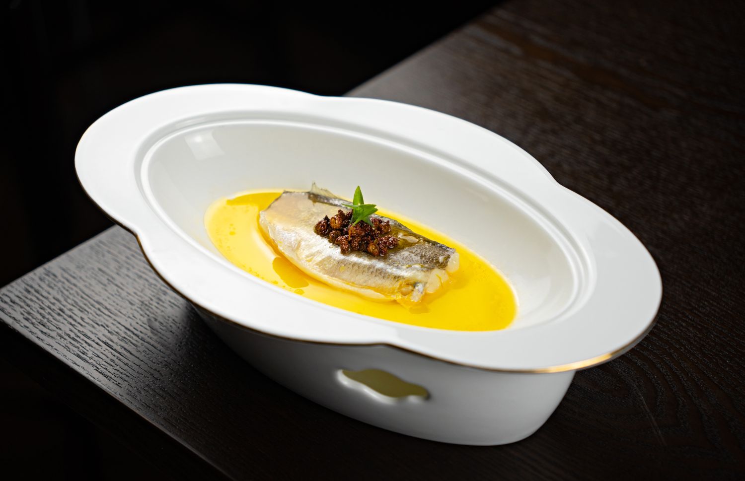 Filet de sandre dans un beurre safrané, servi dans un plat blanc